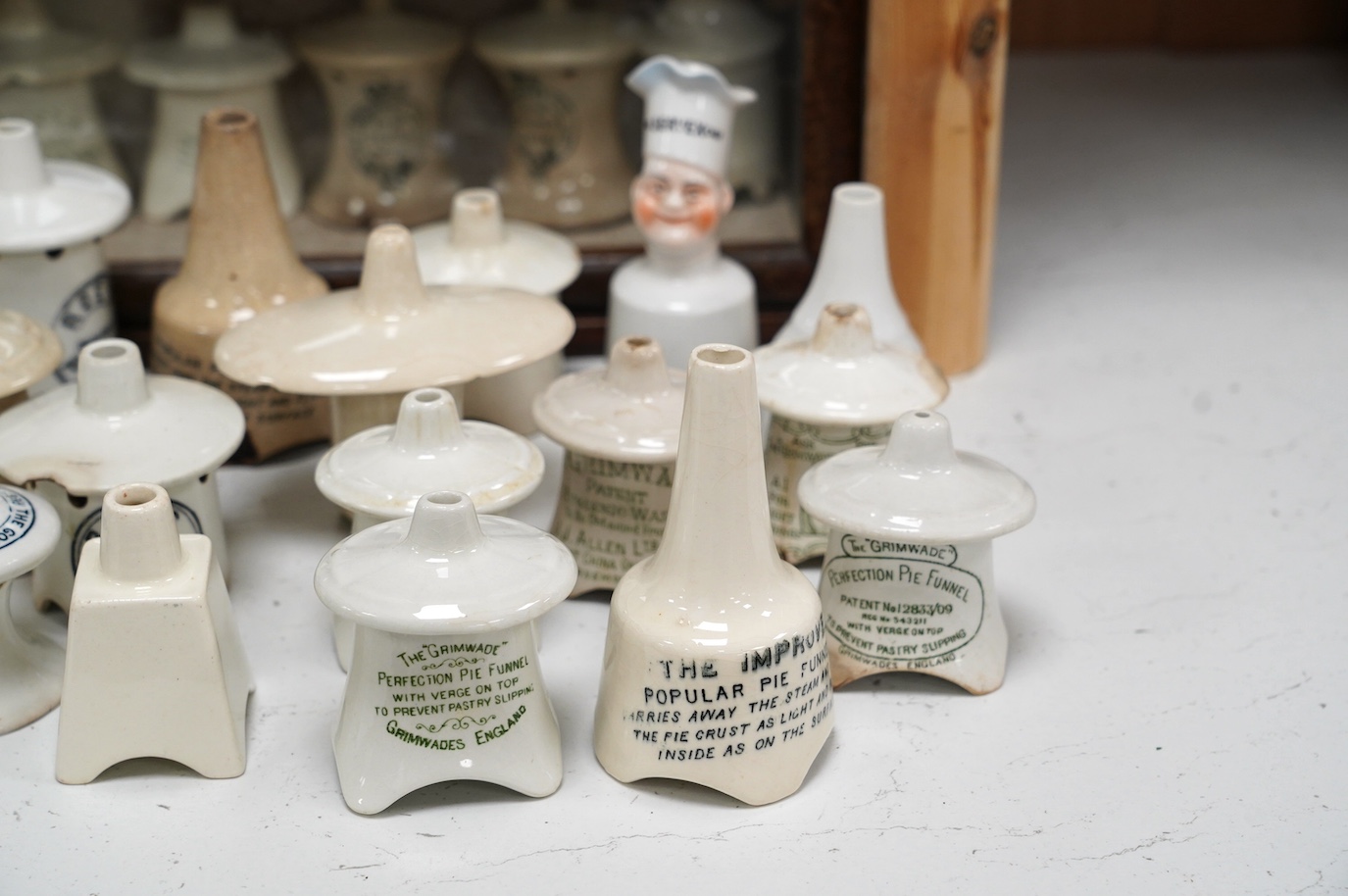 Approximately fifty assorted Victorian pottery pie funnels, some contained within a mahogany display case. Condition - varies